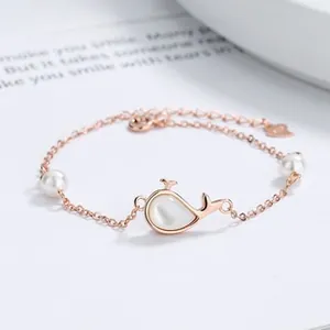 Detail of rose gold whale tail pendant with mother of pearl and pearls on S925 silver chain