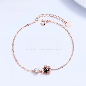 Detail of rose gold astronaut planet bracelet with black stone and cubic zirconia