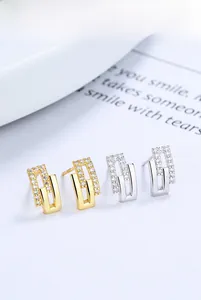 Detail of 925 sterling silver geometric hollow earrings with micro-inlaid zircon stones