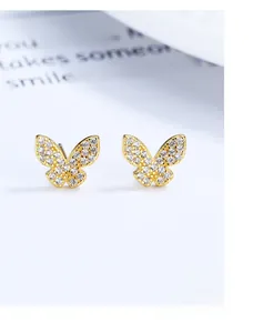 Macro view of gold butterfly stud earrings with micro-paved cubic zirconia crystals
