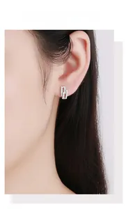 Macro detail of geometric S925 silver stud earrings with micro-inlaid rhinestones