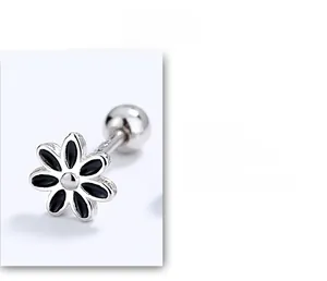 Macro detail of S925 sterling silver daisy stud earrings with black enamel petals