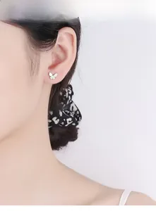 Detail view of a 925 silver butterfly stud earring with micro-pave crystals on ear