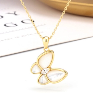 Close-up of gold butterfly pendant with white mother-of-pearl wings and marquise zircon