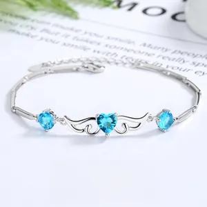 Macro detail of S925 silver bracelet featuring blue heart crystals and silver wings