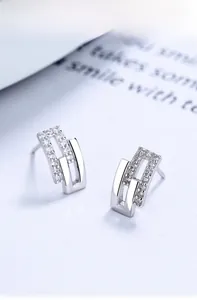 Macro shot of interlocking geometric s925 silver stud earrings with zircon inlay