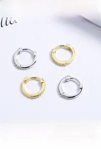 Détail de boucles d'oreilles créoles S925 en or et argent avec zircons étincelants