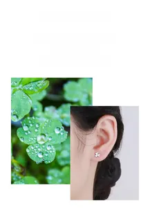 Detail of silver clover earrings inspired by nature shown on a model's earlobe