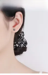 Detail of a minimalist black enamel sunflower stud earring in S925 sterling silver