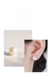 Détail de boucles d'oreilles perles avec zircon sur clous en argent 925 portées