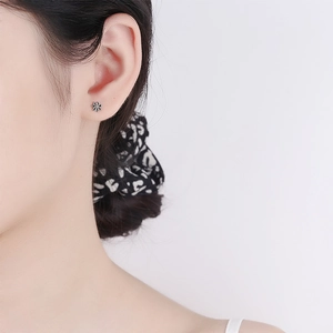 Minimalist S925 sterling silver daisy stud earrings with black enamel center on ear