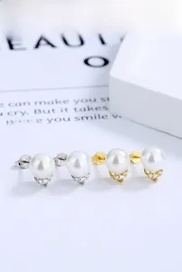 Détail de boucles d'oreilles en argent S925 avec perles et zircons, finitions or et argent