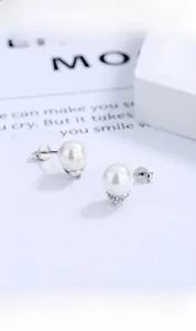 Détail de boucles d'oreilles perles en argent S925 avec zircons sur boîte cadeau
