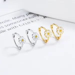 Detailed macro view of 925 silver daisy earrings in gold and silver finish with enamel