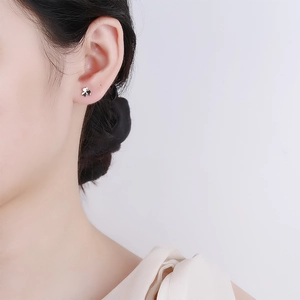 Elegant 925 sterling silver clover flower stud earring on ear with minimalist style