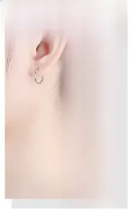 Detailed view of silver bamboo texture hoop earrings worn on ear for minimalist style