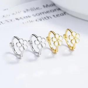 Detail view of 925 silver daisy hoop earrings in gold and silver with white enamel petals