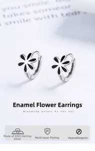 Gros plan de boucles d'oreilles créoles fleurs en argent 925 et émail noir sur blanc