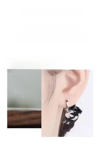 Detailed macro view of S925 silver hoop earrings with pink heart cat eye stone pendants
