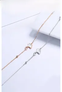 Close-up of ginkgo leaf pendants with white mother-of-pearl and crystal on fine chains