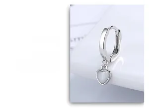 Close-up of a polished S925 silver hoop earring with a heart-shaped opal pendant