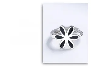 Détail de créoles en argent 925 avec fleurs en émail noir et finition polie brillante