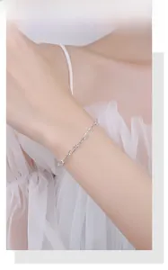 Macro shot of a minimalist 925 sterling silver chain bracelet on a female wrist