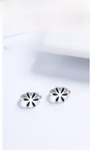 Gros plan détaillé de boucles d'oreilles en argent 925 avec pendentifs fleurs en émail noir