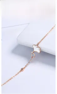 Macro shot of rose gold ginkgo leaf bracelet with white mother of pearl heart and zircon