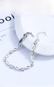 Detail of silver S925 bracelet with blue crystals and a delicate heart charm