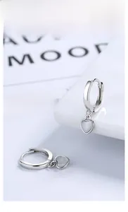 Macro view of S925 sterling silver heart earrings with white cat eye stone accents