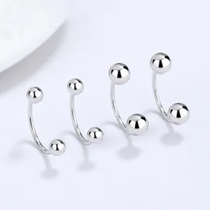 Macro shot of silver horseshoe earrings with double round balls in multiple sizes