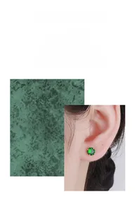Detailed close-up of emerald zircon stud earring with gold-plated four-prong setting