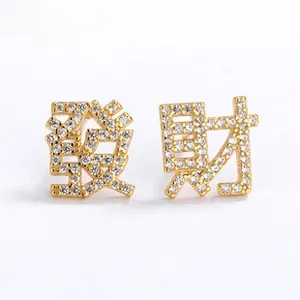 Close-up of golden S925 silver stud earrings with Chinese characters and cubic zirconia