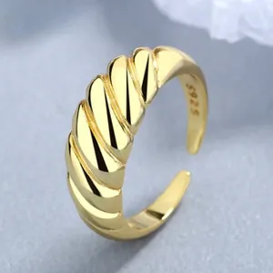 Macro detail of S925 sterling silver gold-plated ring with twisted croissant texture