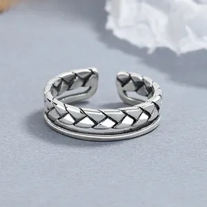 Macro detail of retro 925 sterling silver braided double-layer open ring for women