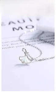 Vue détaillée du pendentif feuille de ginkgo en argent avec incrustation de nacre blanche