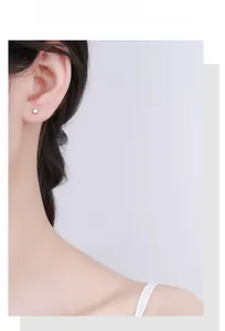 Close-up of minimalist white plum blossom 925 silver stud earring on female ear