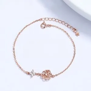Macro detail of rose gold floral bracelet featuring hollow rose charm and zircon stones