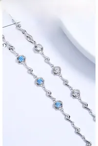 Macro detail of S925 silver bracelet with blue and white zircons in floral settings