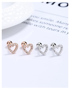Macro shot of silver and rose gold heart ear studs with cubic zirconia and screw back