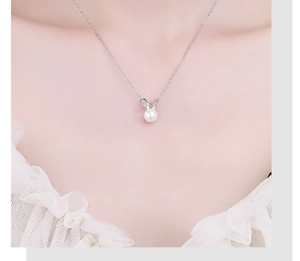 Macro view of a 925 silver rabbit pendant with a lustrous white pearl and zircon inlay