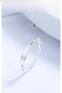 Macro detail of 925 silver twist ring featuring a brushed rectangular plate design