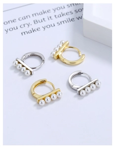 Detailed close-up of S925 silver huggie earrings with four inlaid pearls in gold and silver