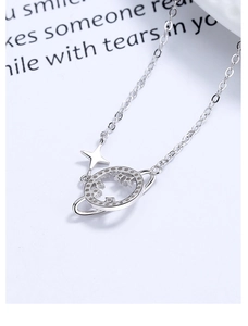 Detail of 925 sterling silver hollow planet necklace with sparkling star charm