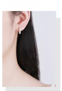 Close-up of s925 silver hoop earrings with four elegant white pearls on model ear