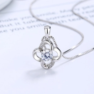 Detailed view of silver clover pendant with central sparkling gemstone and micro-pave petals
