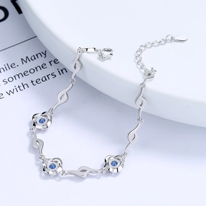 S925 sterling silver clover bracelet with three blue crystal roses on a white plate