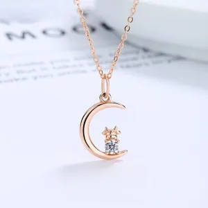 Détail du collier croissant de lune en or rose avec pendentif bœuf et pierre de zircon