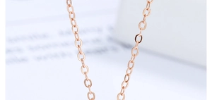 Macro view of polished rose gold cable chain links and smooth metallic texture